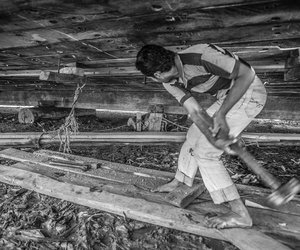 A labor is repairing bottom of a dhow 