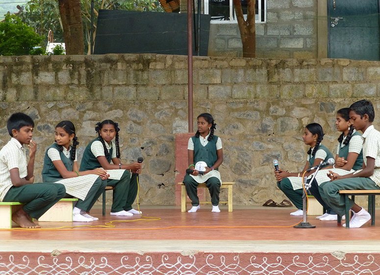 Left: Vidya Vanam students, most of them from Adivasi and Dalit communities, begin their spirited and informed debate on genetically modified crops. Right: The moderator looks at the clock she is using as a stopwatch, while a debater makes her point