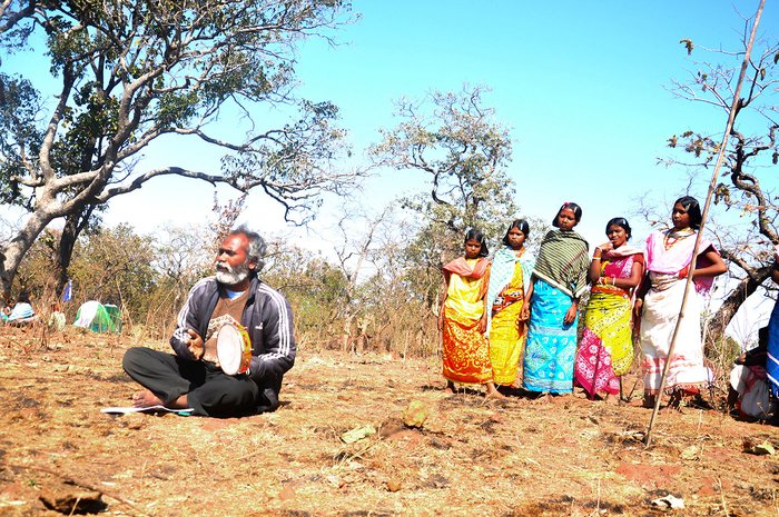 Rajkishor Sunani sings a song while people gather around him to listen