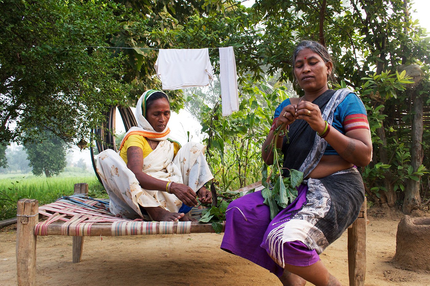 Rajkumari and Sukalo cleaning greens at Sukalo’s house