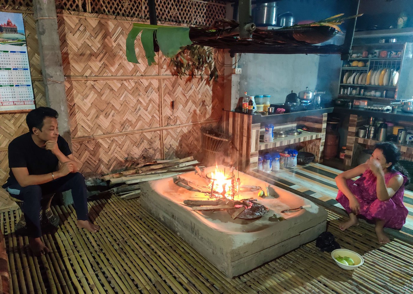 Monjit and his wife, Nayanmoni Risong, sitting next to the marom . The parap is the scaffolding on top of the marom that is used to store wood and dried fish during the monsoons