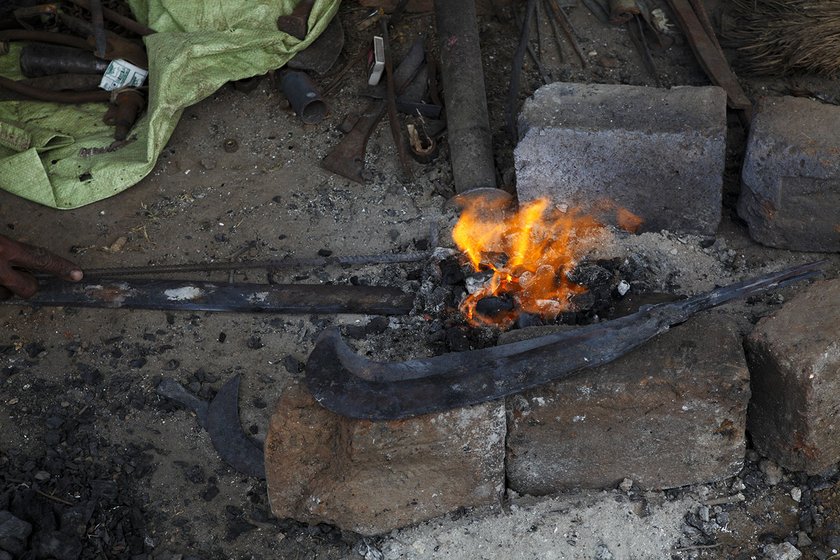 Surekha and Chaburao heat the metal in a makeshift furnace 