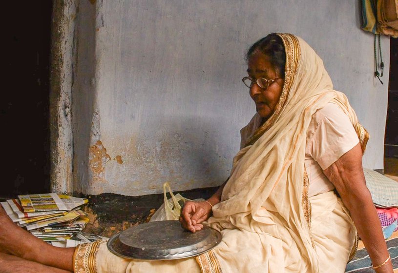 Chobi Saha getting ready to make paper bags. ‘First, I use a knife to divide a paper into three parts. That makes six pieces. Then I apply glue in circles. After that I fold the paper into a square and apply glue to the other side. This is how I make the packets,’ she says as she works]