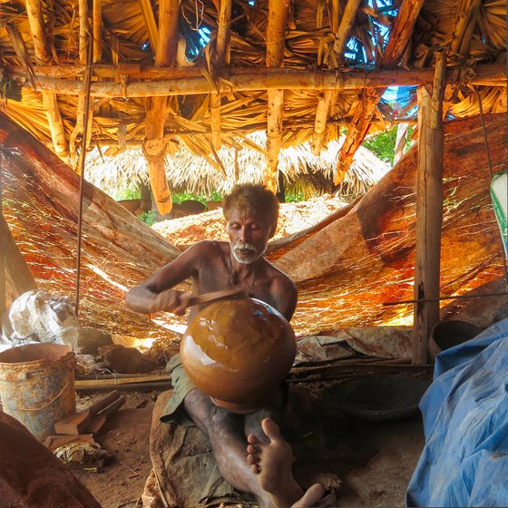 Mulampaka Bhadraraju uses a chekka sutti (left) to smoothen the pot.