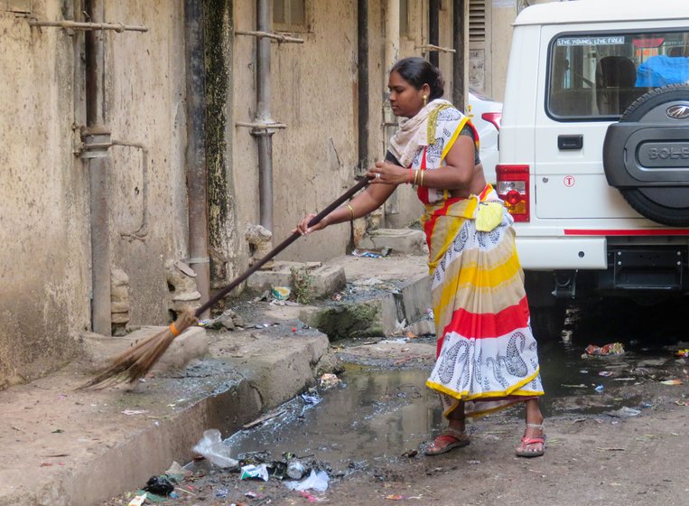 Left: On Saturday, like on all their work days, safai karamcharis gathered at 6 a.m. at the chowki in M-West ward, ready to start another day of cleaning, at great risk to themselves. Right: Among them is Anita Ghotale, who says, 'We got these masks only yesterday [on March 20], that too when we demanded them due to the virus'


