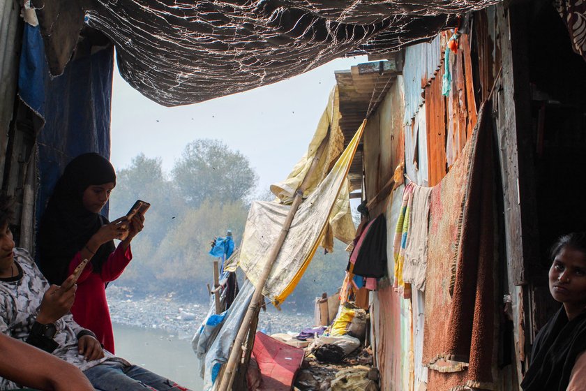 Left: Kitabun outside her 100-square feet room next to a nallah. Right: It shelters 16 people, including her grandkids