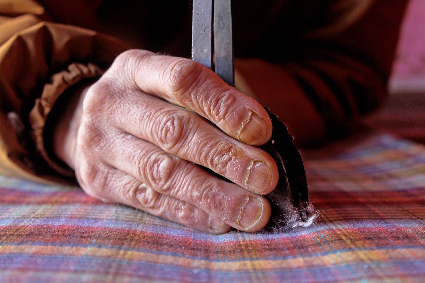 Working with an iron wouch, Abdul removes lint from the shawl