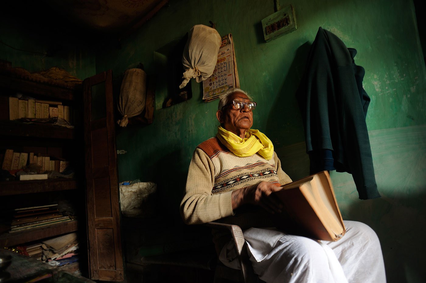 Man sitting in a room with a book in his lap