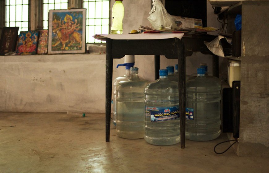 Cans of drinking water stored underneath a table in a house