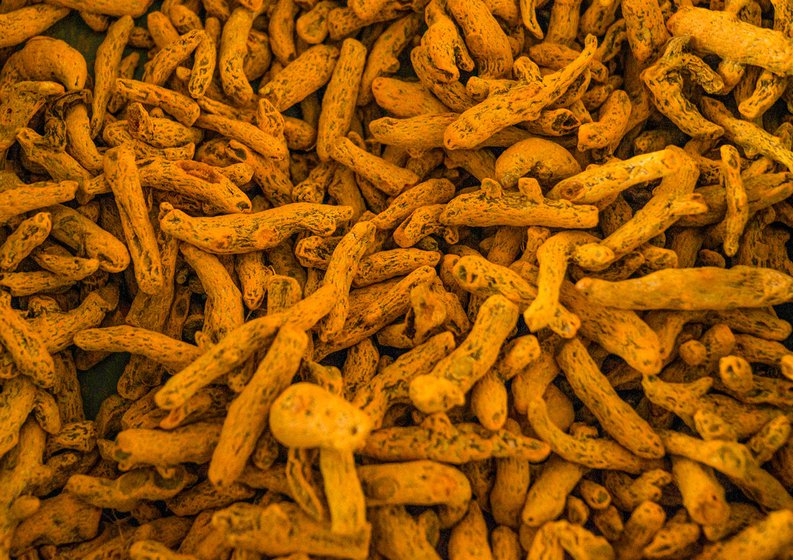 Trays with the lots of turmeric fingers and bulbs displayed at an auction in the regulated market in Perundurai, near Erode