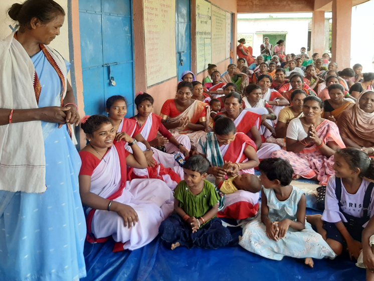 Lakra has fought the bribery allegations with her own limited resources. With her are other women (right) from Tetra village, gathered at the village middle school building