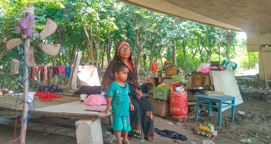 Shanti Devi (right) taking care of her grandsons while the family is away looking for daily work.