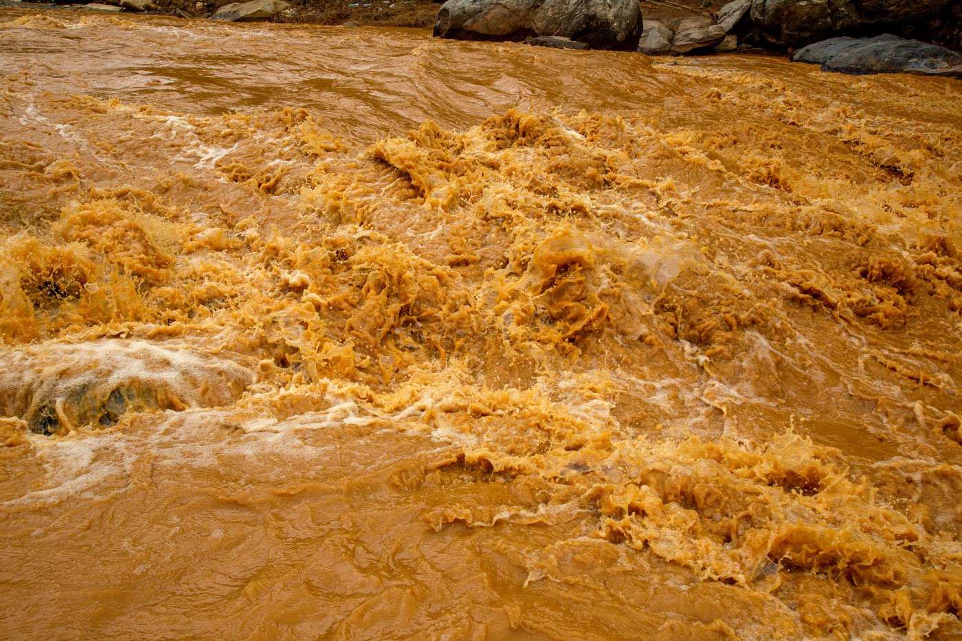 The fast flowing river has turned brown carrying soil eroded by heavy rain in the Mundakkai and Chooralmala regions