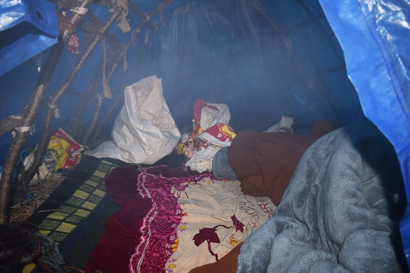 Inside the tarpaulin camp of Gopal Singh. The rugs and blankets are carried up from his village. He has been living here for more than a month