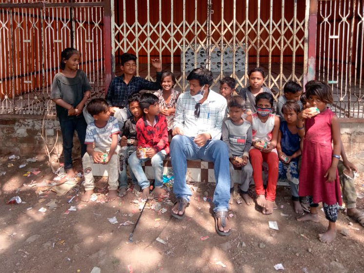 Left: A file photo of Tatwashil Kamble with a few homeless children. Right: Kamble and Ashok Tangde (right) at a Pardhi colony in Beed after distributing ration kits