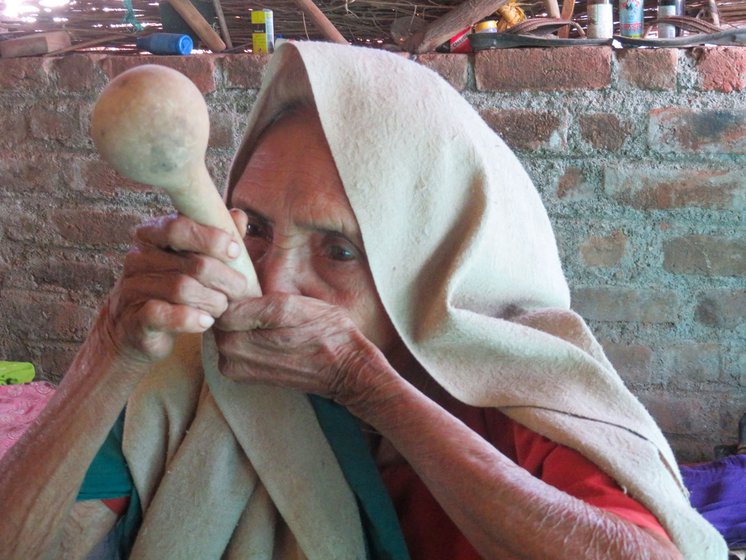 Rukhabai demonstrates how to drink water with a dawi (left) which she has stored safely (right) in her trunk