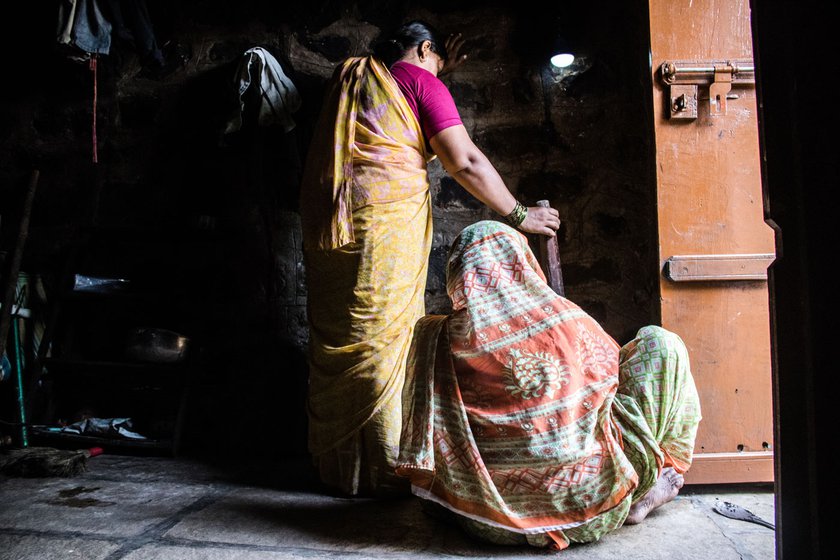 Right: In neighbour Vandana Magdum’s house, Kusum and Vandana begin the process of crushing the baked castor seeds