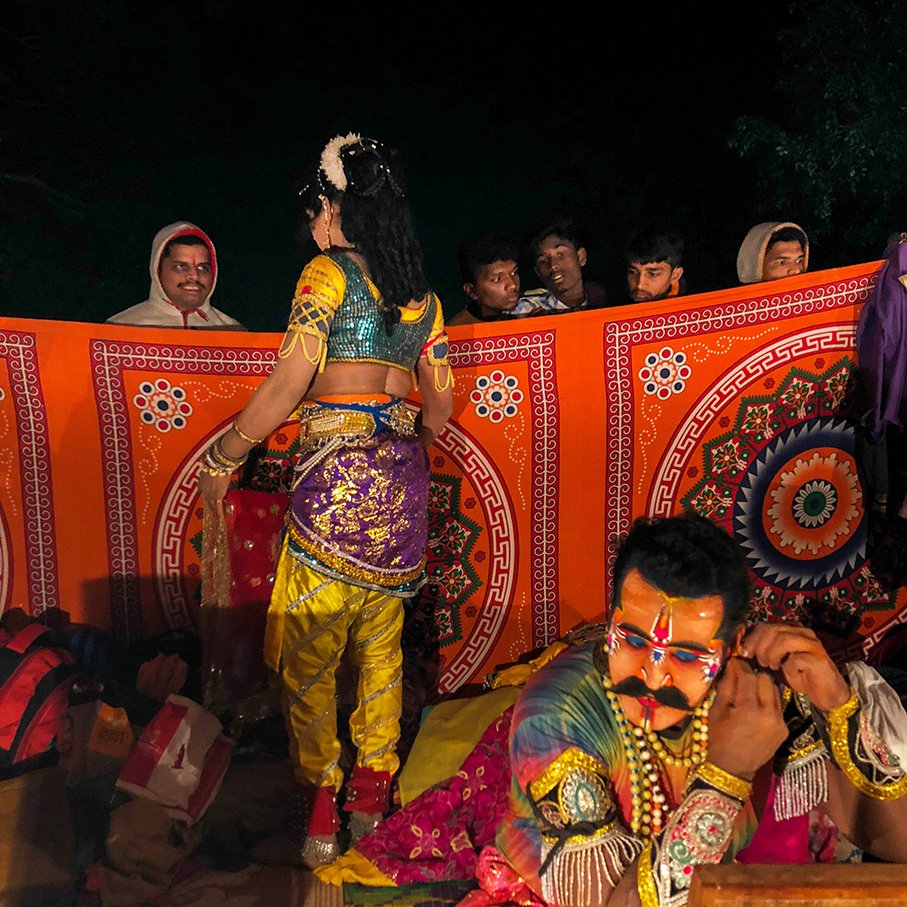 audience peek at the performers as they get ready in a makeshift dressing room at the Mansishwar jatra