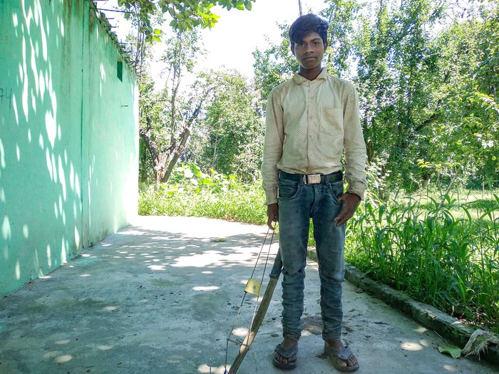 Suraj getting ready to scare birds away with a kaman. He was hoping he could earn enough from this job to get back into school