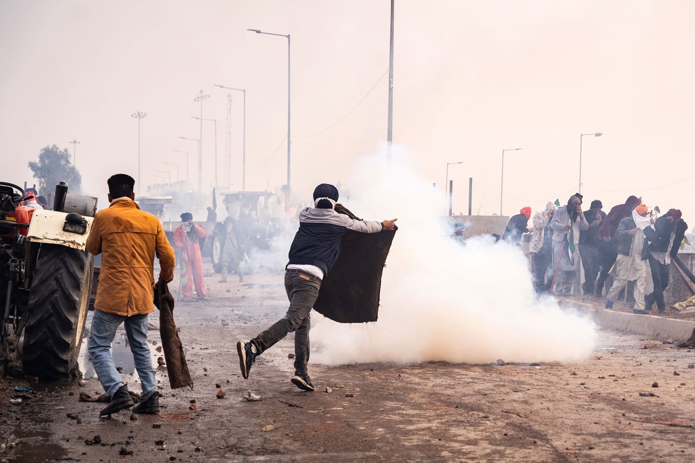 The crowd tries to break through the second barriers as they are attacked by tear gas shells