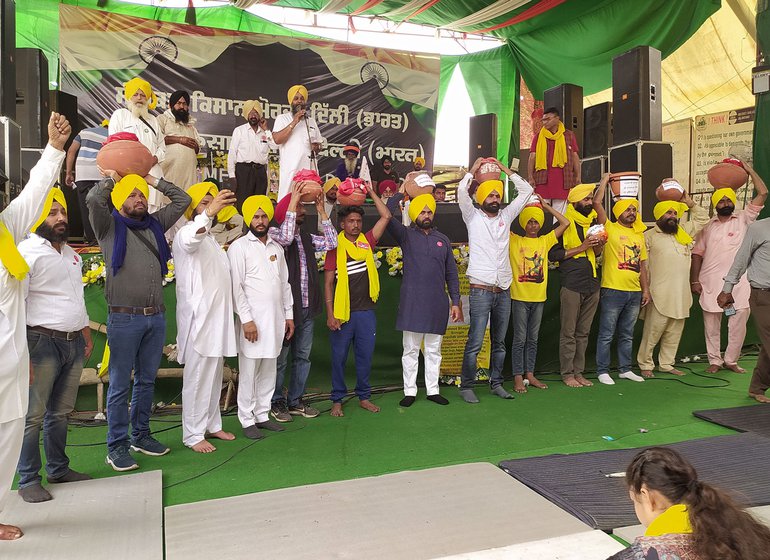 All eyes watched in anticipation as eight young men climbed onto the stage of the Samyukta Kisan Morcha at Singhu carrying the earthen pots on their heads