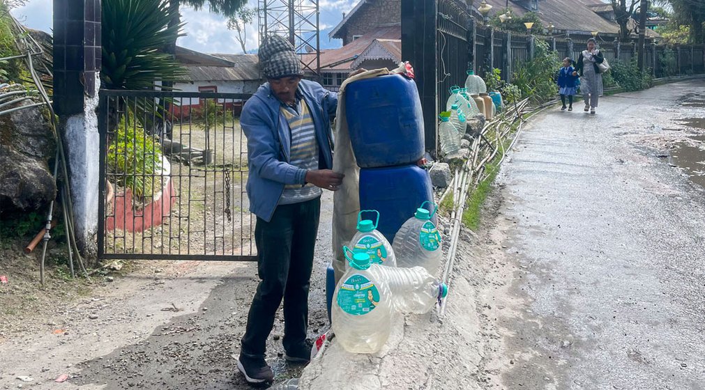 Asti Thami (left) and Jungey Thami (right) carrying water cans for delivery