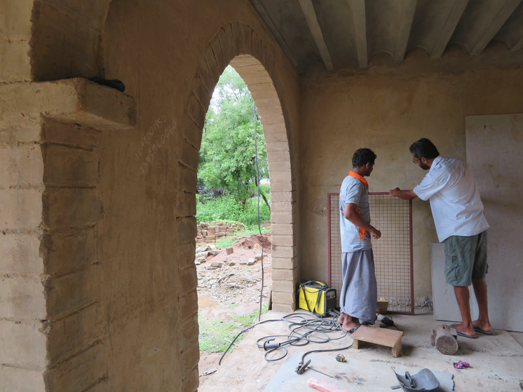 Kumar installing window grilles at the new campus.