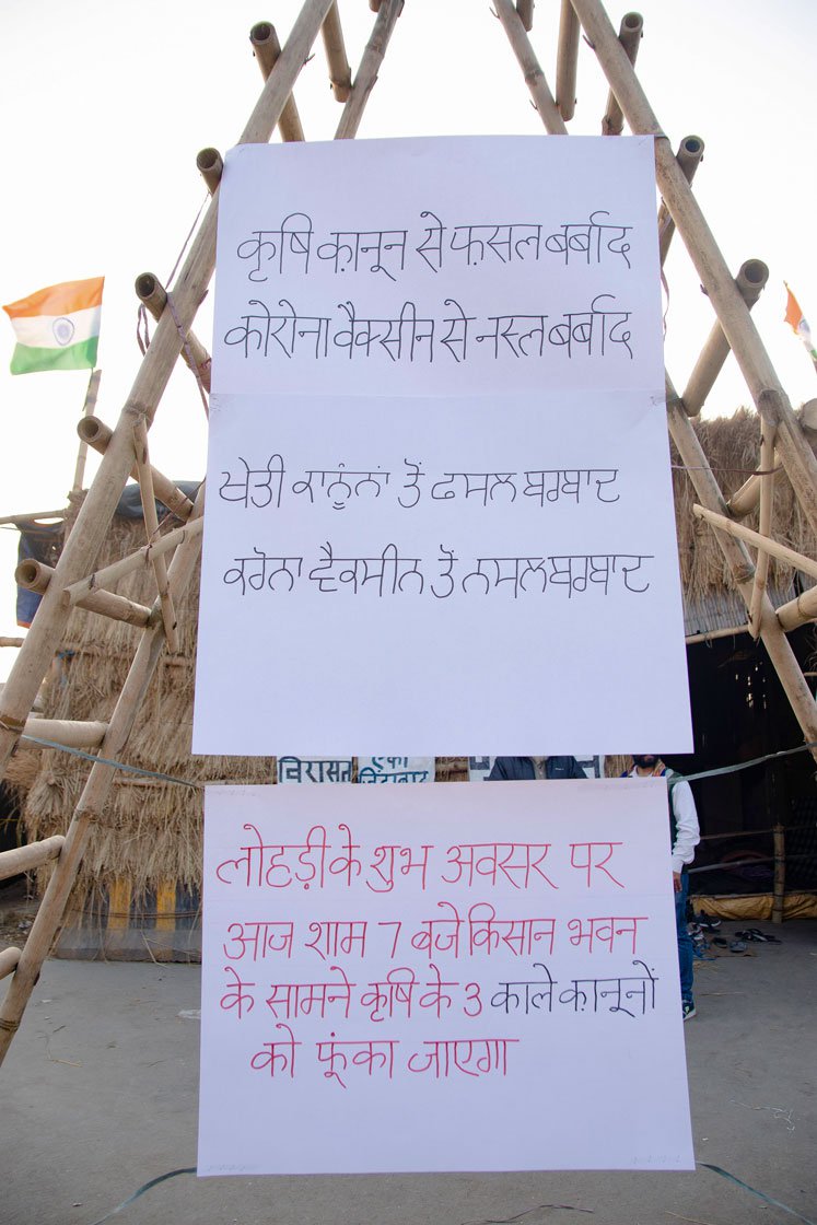 Left: Posters announcing that the three farm laws will be burnt at 7 that evening on the occasion of Lohri. Right: Farmers raise slogans as the Lohri fire burns.