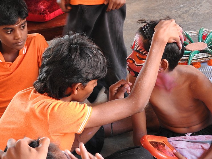 A young student studies the finer nuances of face painting