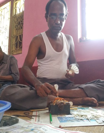 Holding each feather by the quill, grafting expert Tapas Pandit dabs the bottom with a bit of natural glue. Using a shonna (tweezer), he fixes each feather into the drilled holes one by one, making them overlap.