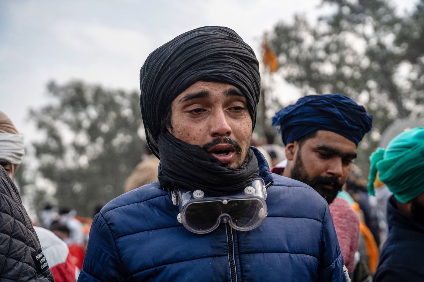 A farmer struggles as he is hit by a tear gas shell