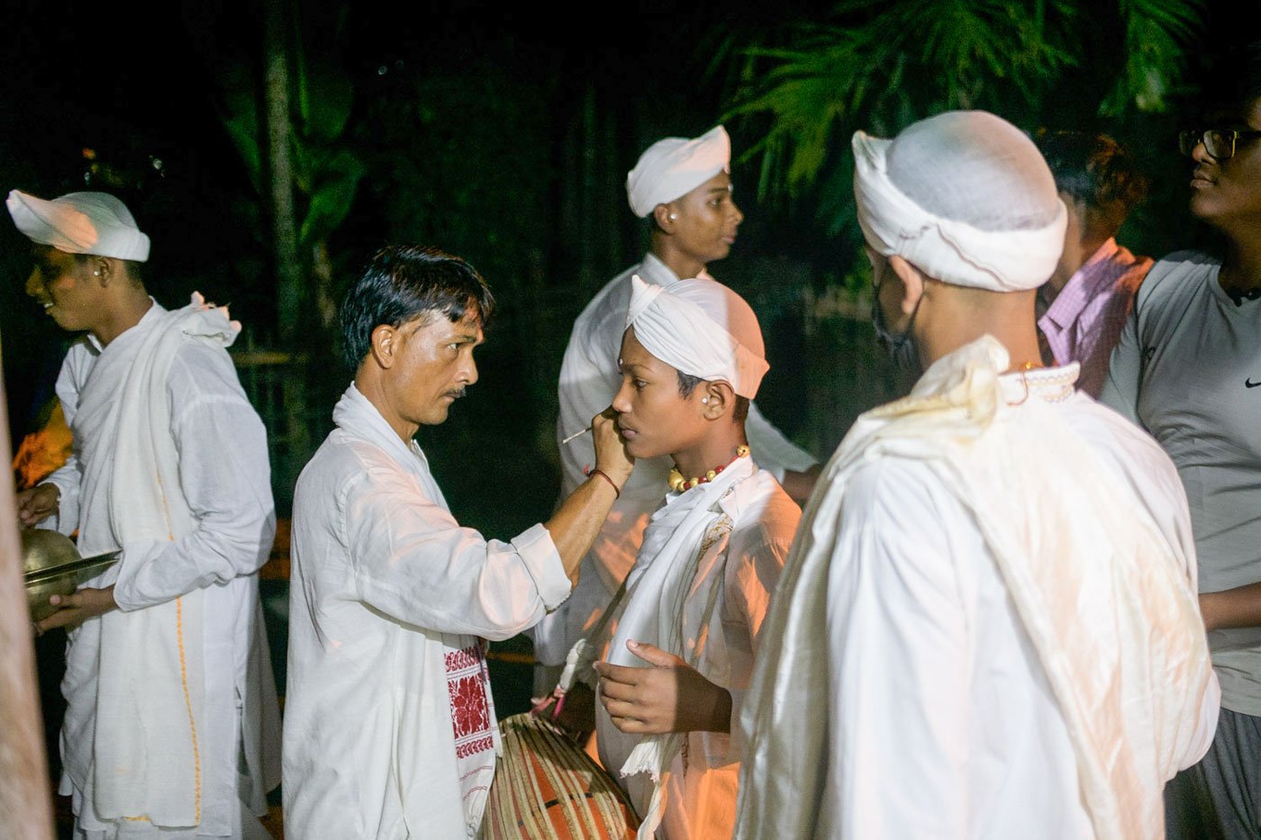 Nityananda Dutta applies mrittika tilak on Jyotishman as the group of young gayan-bayans gets ready to go on stage