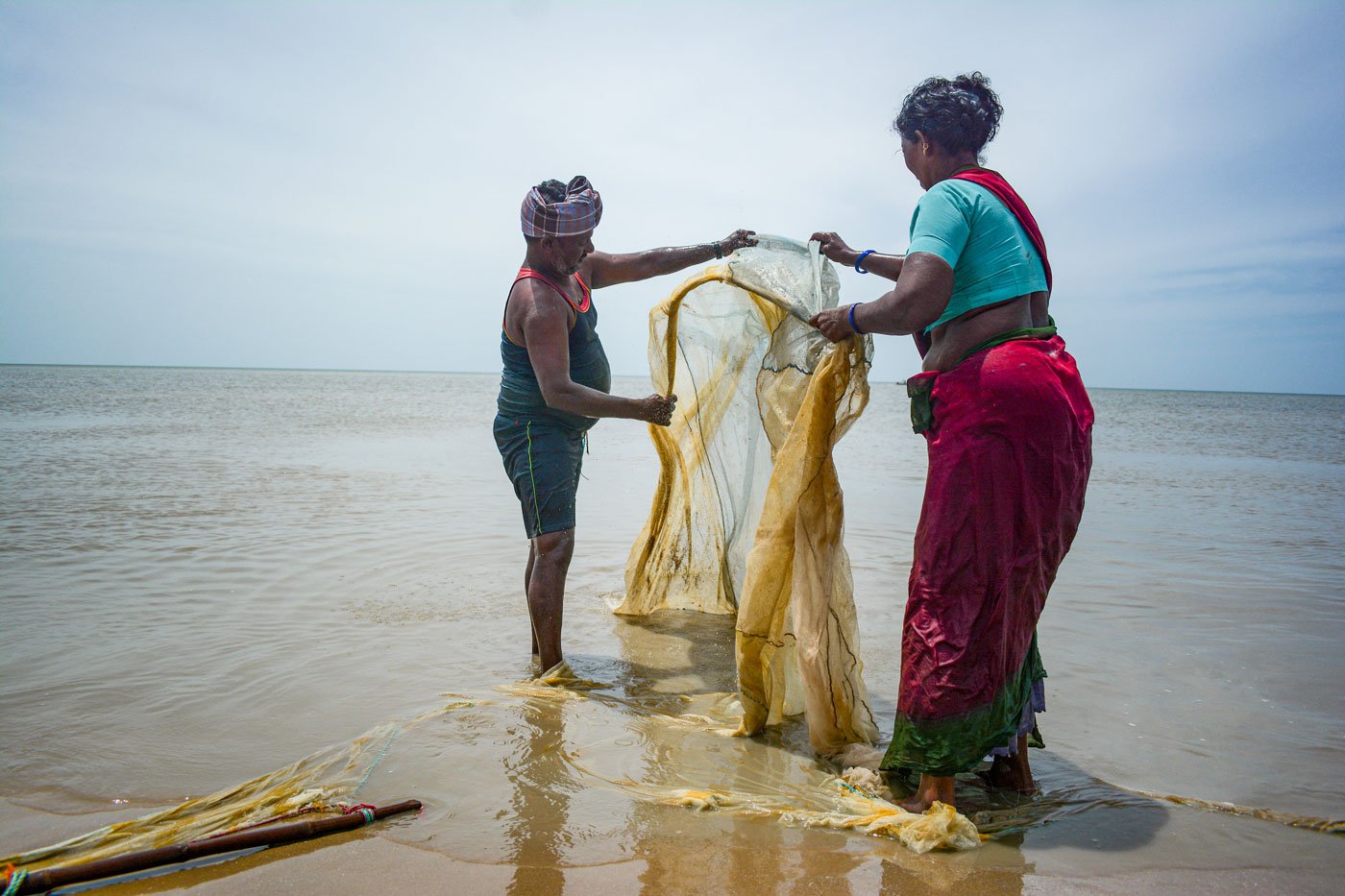 Arumugam and Kuppamal thoroughly check the net for prawns at Vanavanmahadevi in Nagapattinam.