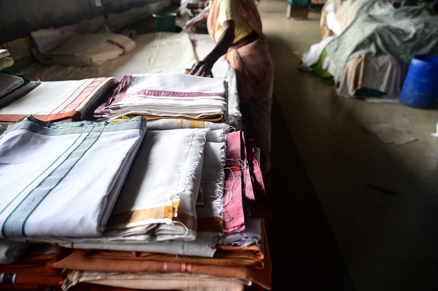 Sarojini meticulously folding a pile of freshly laundered clothes