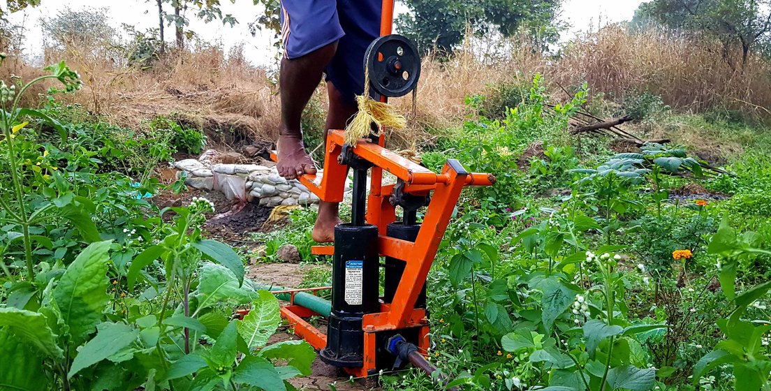 Left: 'We have not even got permission to construct a house on the plot'. Right: The plot is uphill, near their old house; a paddle machine that lifts water eases their labour