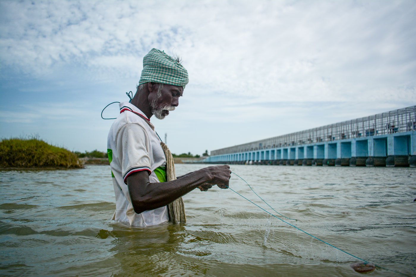 In Avarikadu, Kesavan prepares to throw the nets in the canal.