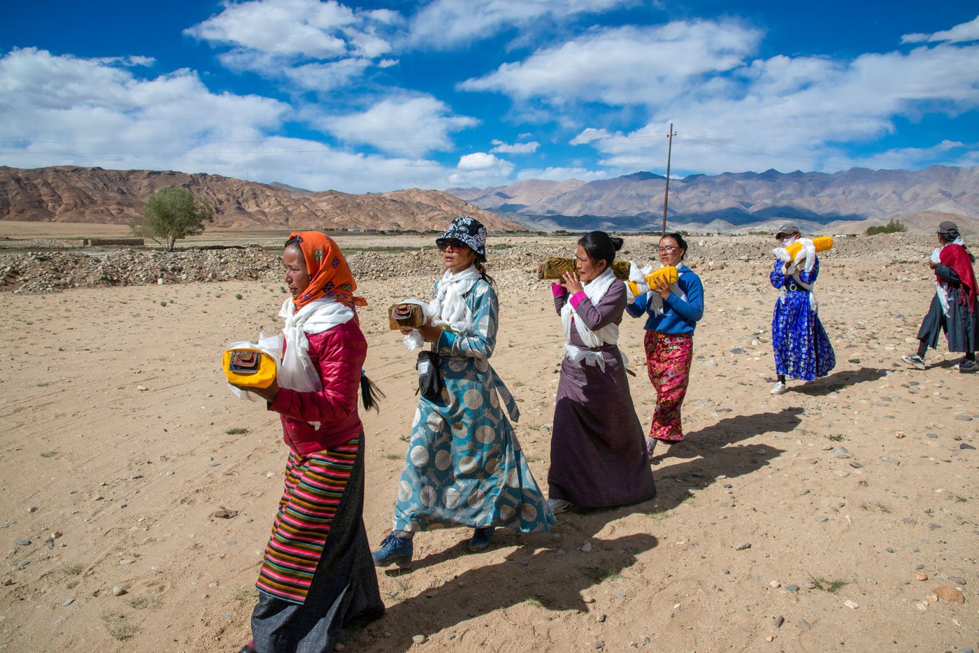 Women in the procession carry the holy scrolls on their shoulders as they walk