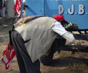 A marcher drinks water from a Delhi Jal Board water tanker.