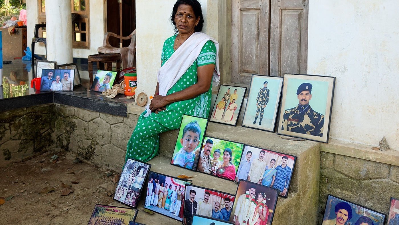 woman sitting outside house, Photos kept to dry