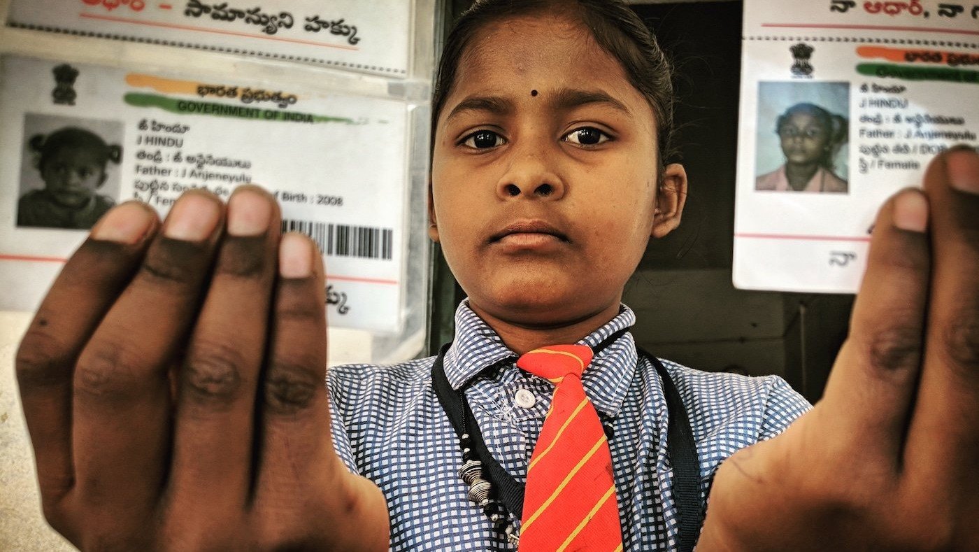 J. Indu holding her Aadhaar cards with her name misspelt 