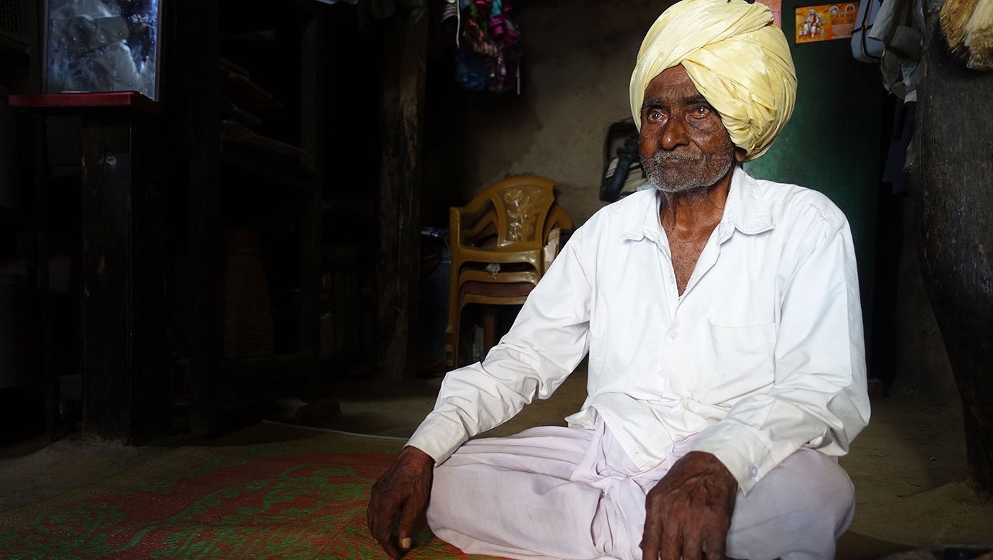 Old man sitting inside home