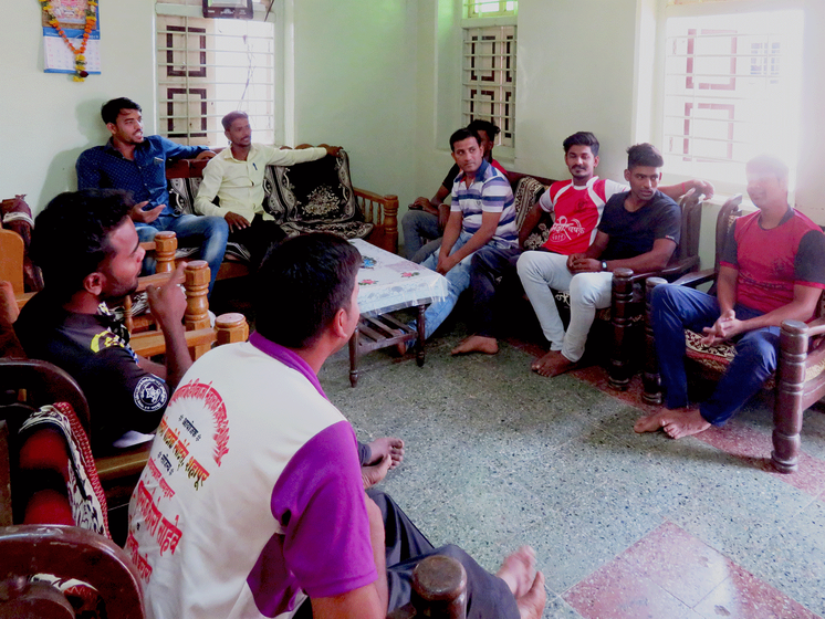 Young men gather at a house in Shendrun village to speak of the elections