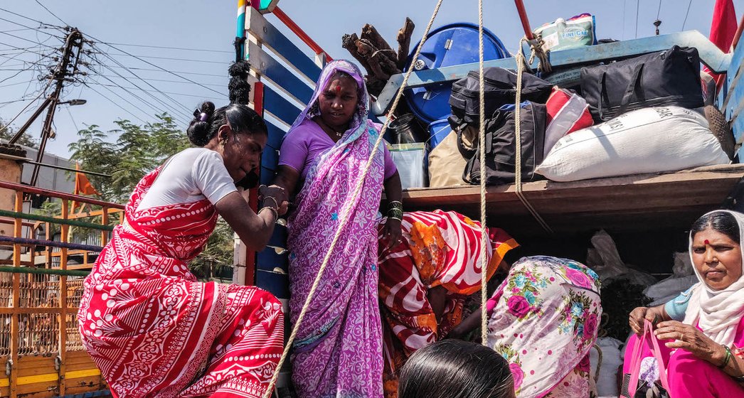 Women boarding the truck, heading towards the march. 