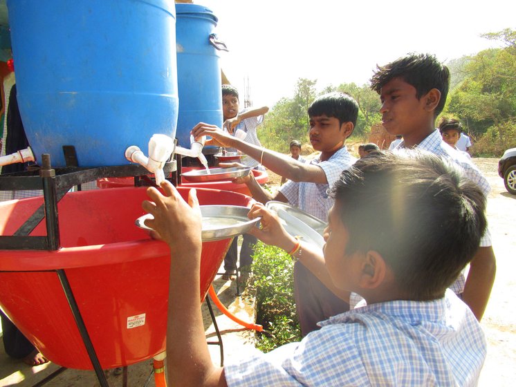 The students at the Dhondmaryachimet ZP school wash their plates before eating their mid-day meal of rice and dal 