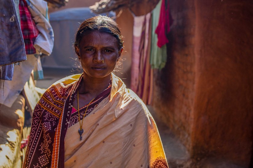 Supari Putel in front of her mud house and the family's incomplete house (right) under the Pradhan Mantri Awaas Yojana: 'This house cost me my husband'