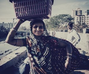 Woman carrying basket full of utensils