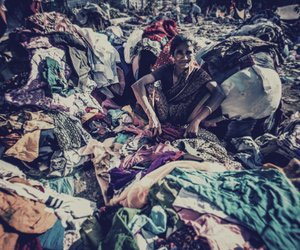 Vaghri woman, sitting amidst used clothes