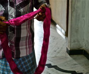 Man holding up silk thread