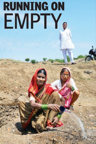 Two women sitting on ground with man standing behind