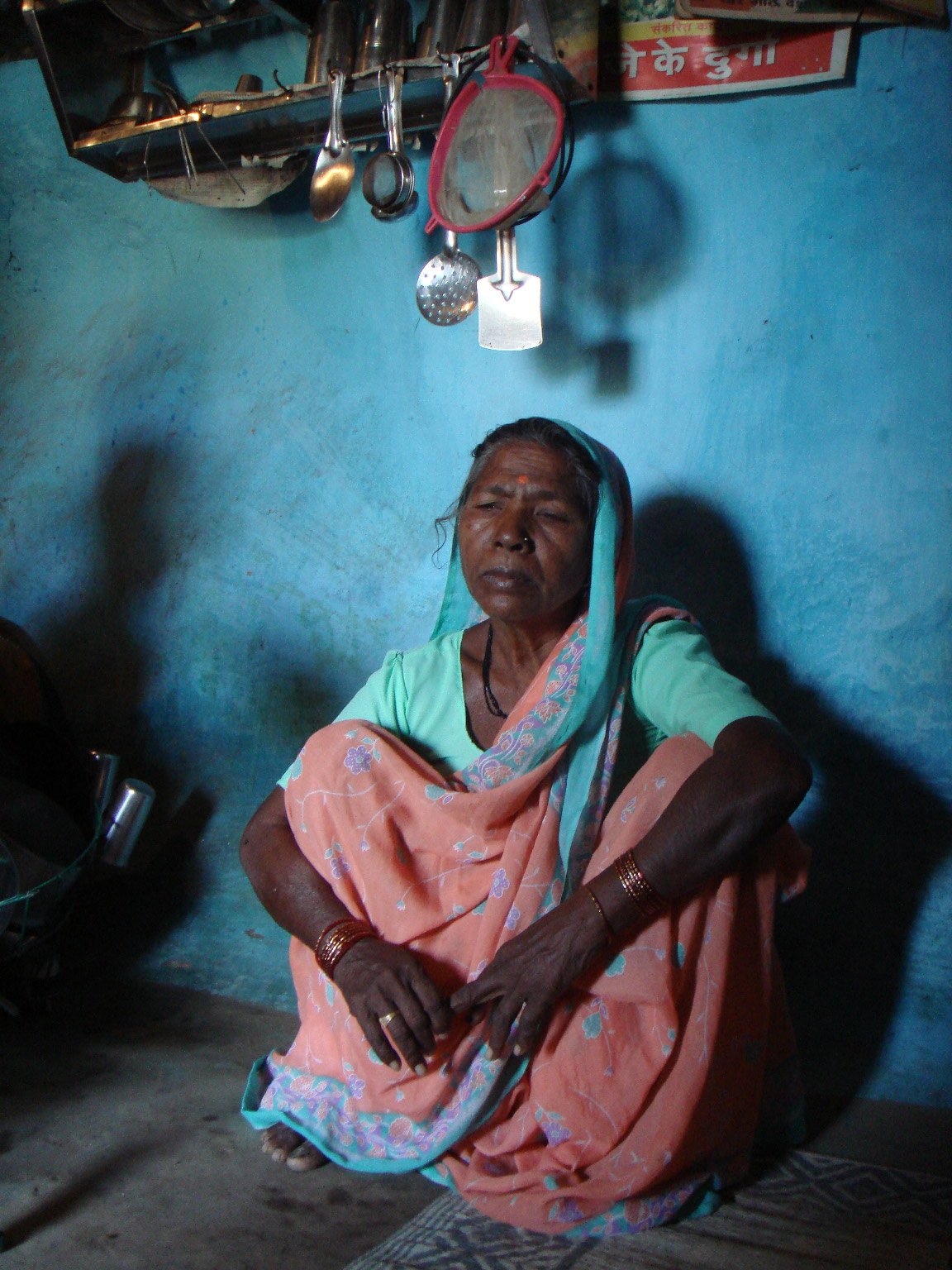 Kamlabai sitting in front of blue wall